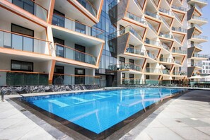 Un edificio moderno con varios balcones y una piscina.