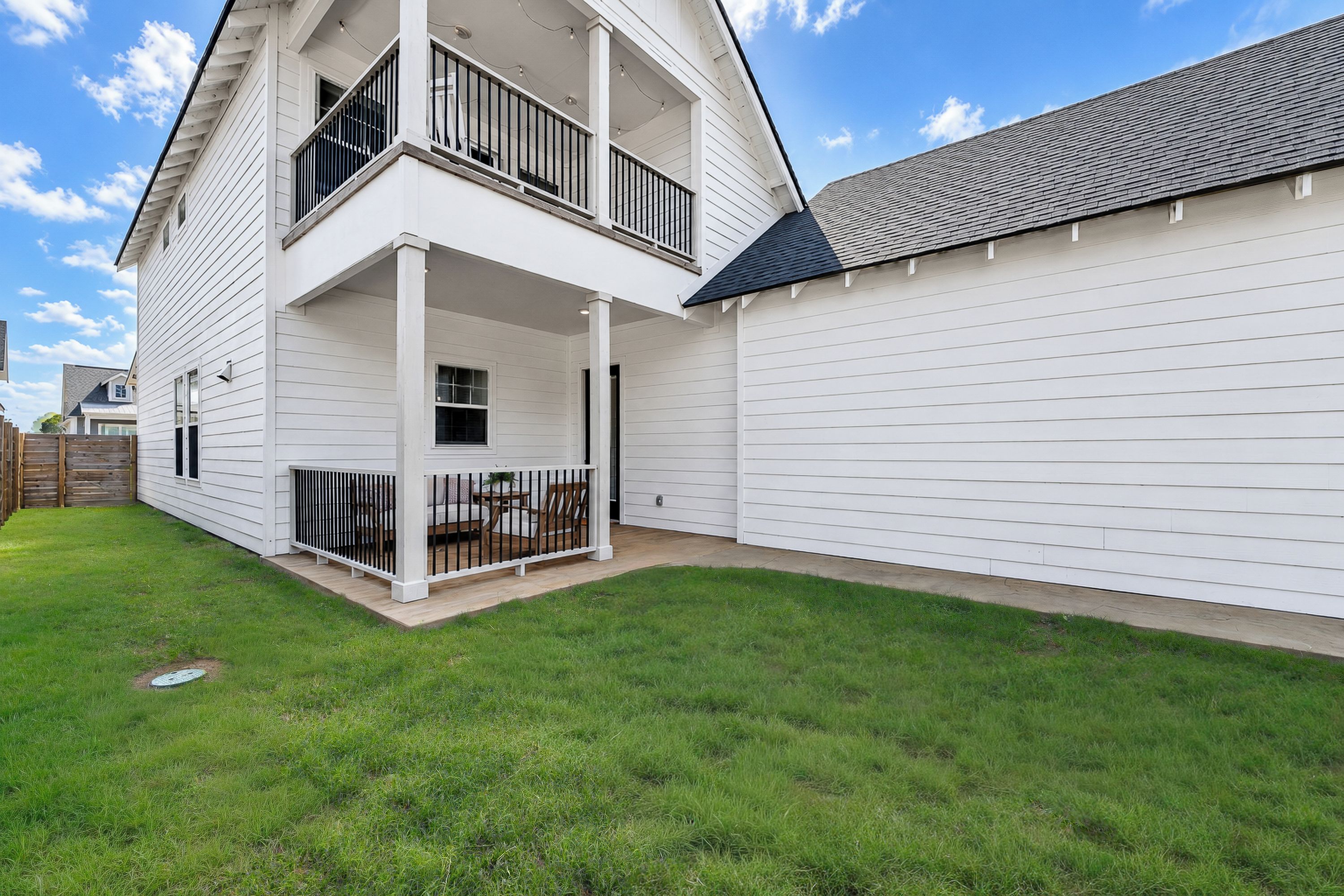 A two-story residential building with a covered patio area.