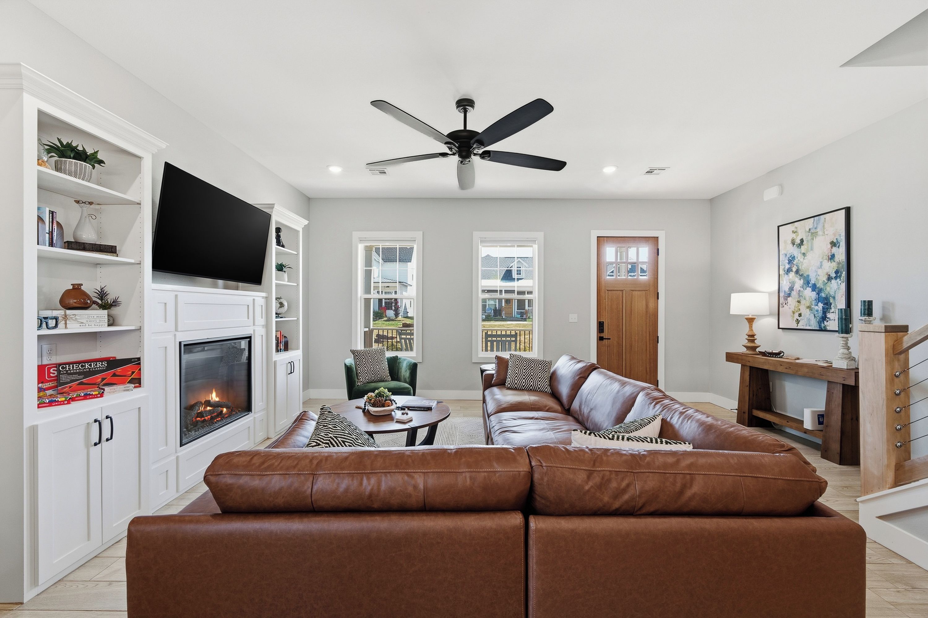 A modern living room with a fireplace, leather sofa, and a television.