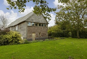 Ein Haus aus Stein und Holz mit einem geneigten Dach, einer Haustür und einem kleinen Fenster.