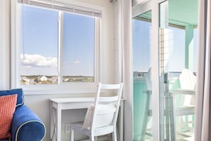A balcony with a white chair and a view of the sea. - SeaSpray 305 | Oceanview Condo w/ Pool (Atlantic Beach)