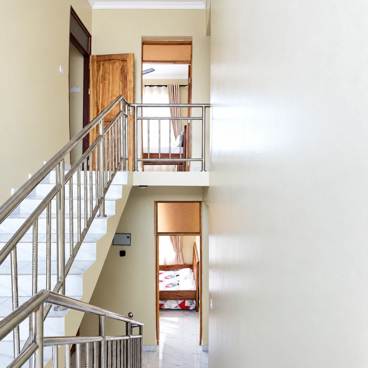 Ein mehrgeschossiges Interieur mit einer Treppe, einem Etagenbett und einer Tür zu einem anderen Raum.