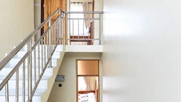 Ein mehrgeschossiges Interieur mit einer Treppe, einem Etagenbett und einer Tür zu einem anderen Raum.