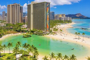 A coastal cityscape with high-rise buildings, a beach, and clear turquoise waters. - Ocean & Marina Sunset Condo, Free Parking, Waikiki (Honolulu)