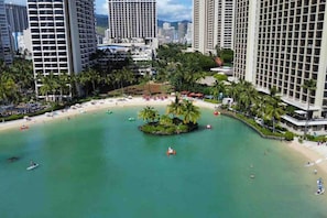 Ein Küstenresort mit Hochhäusern, einer zentralen Insel und einem Strandabschnitt.