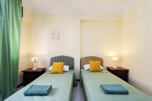 A twin room with two beds, each with a headboard, bedside lamps, and pillows. - Spacious and bright apartment in the heart of Tangier (Tanger)
