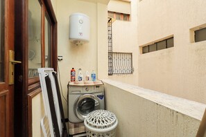 A laundry area with a washing machine, a drying rack, and a water heater. - Spacious and bright apartment in the heart of Tangier (Tanger)