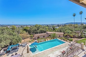 A pool area with a clear view of the surrounding landscape, including a hill and distant cityscape. - Modern Furnished Santa Barbara Courtyard Retreat with Private Deck & Pool (Santa Barbara)