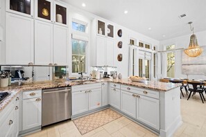 A spacious kitchen with white cabinetry, granite countertops, and a central island. - Playa Maya (Panama City Beach)