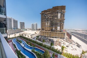A high-rise building with multiple balconies, surrounded by a landscaped area with a swimming pool. - Stayshort - Spacious 2-bedroom Apartment at Skyhills Tower 1 (Dubai)