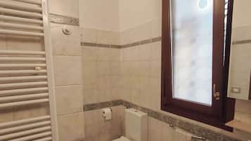 Een badkamer met toilet, bidet en wastafel.