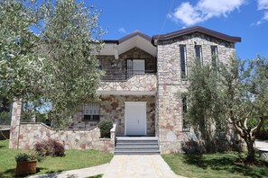 A two-story stone house with a front entrance, a balcony, and a stone staircase leading to the entrance. - Airport comfort nest (Kamëz)