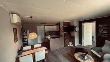 A modern living space with a dining area, kitchen, and seating area.