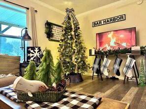 A cozy living room with a Christmas tree, a fireplace, and a sign reading 'BAR HARBOR'. - Coastal Farmhouse,10 min to beach, game room 1 dog (Lamoine)