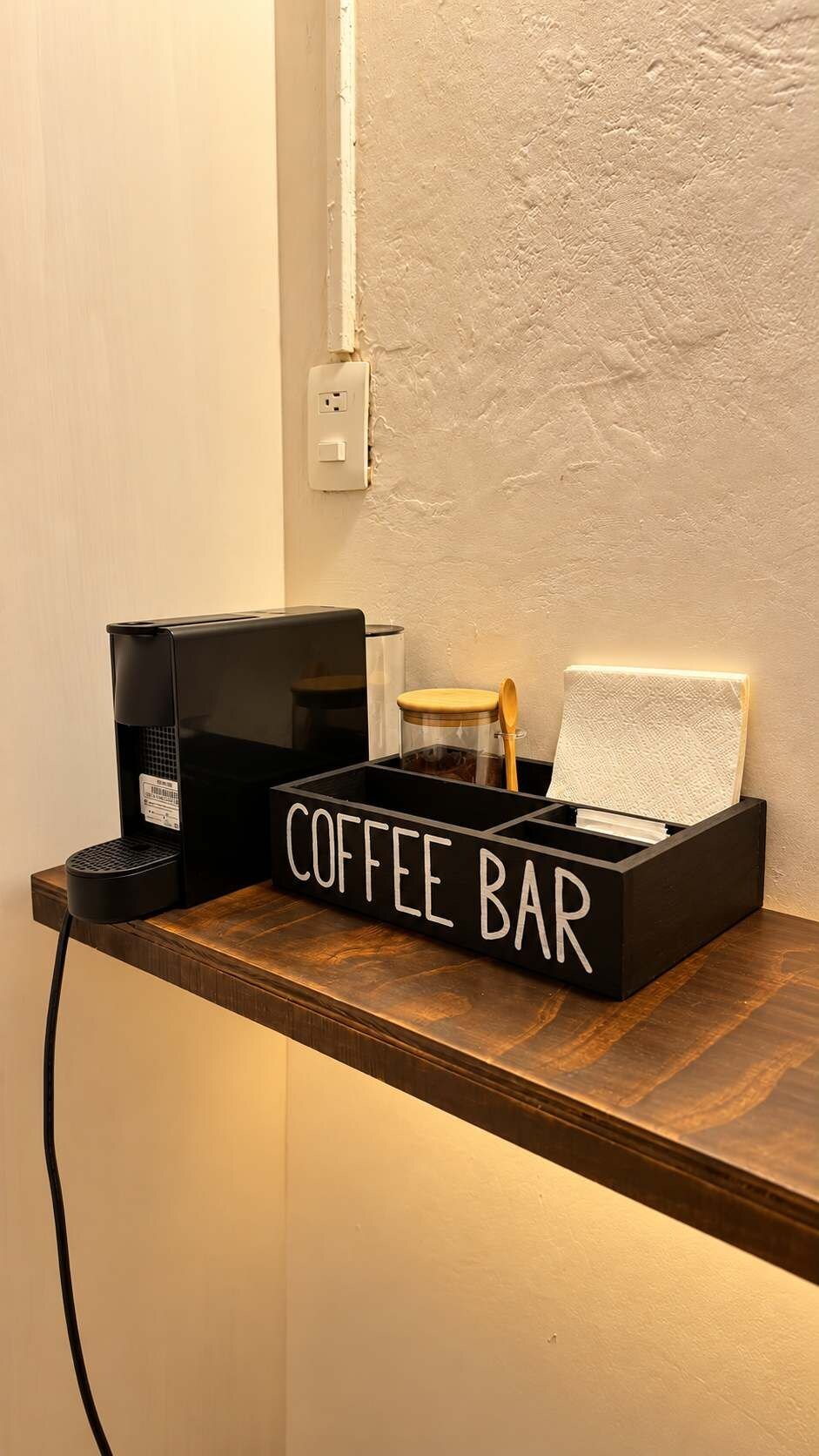 A coffee bar setup with a coffee machine, a coffee grinder, and a tray with a coffee cup.
