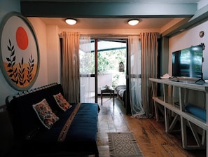 Una habitación con cama, televisión y vistas al exterior.