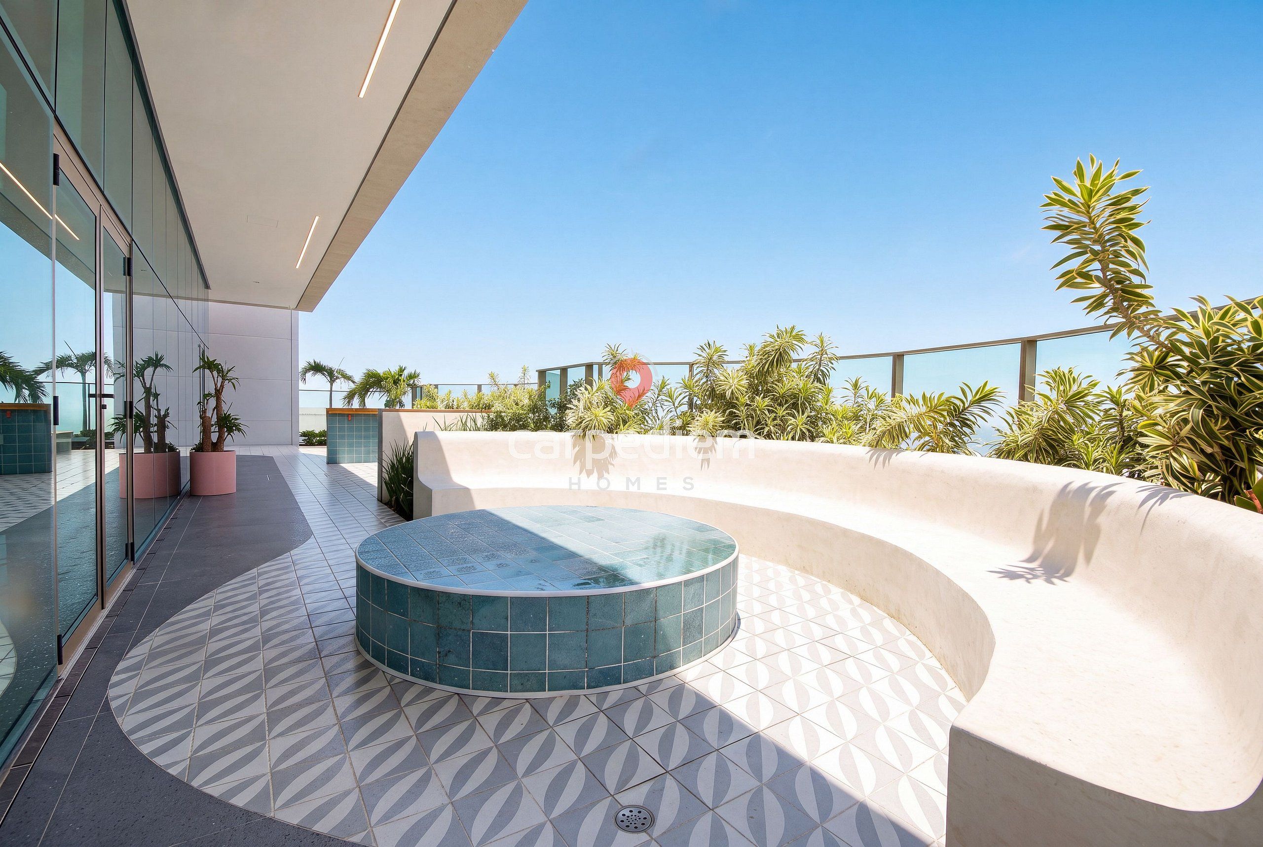 Un espacio exterior moderno con una zona de estar curva, una piscina pequeña y plantas en macetas.