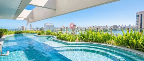 Una piscina infinita en la azotea con vistas al horizonte urbano.