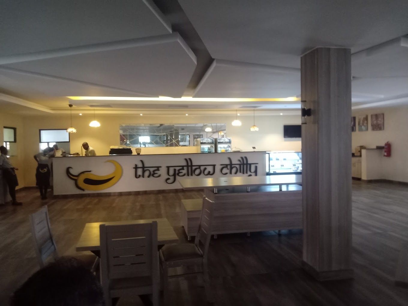 L'intérieur d'un restaurant avec un comptoir, des chaises et un panneau affichant le menu.