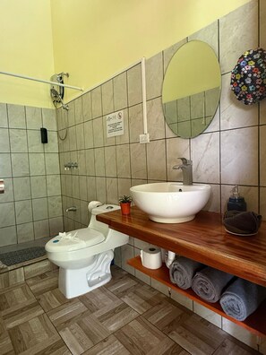 A bathroom with a toilet, sink, shower, and a mirror. - Casa Bocaracá · Moderna · 4 PAX · Aire Acondicionado (Playa Chiquita)