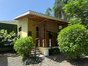 A two-story building with a covered porch and a staircase leading to the entrance. - Casa Bocaracá · Moderna · 4 PAX · Aire Acondicionado (Playa Chiquita)