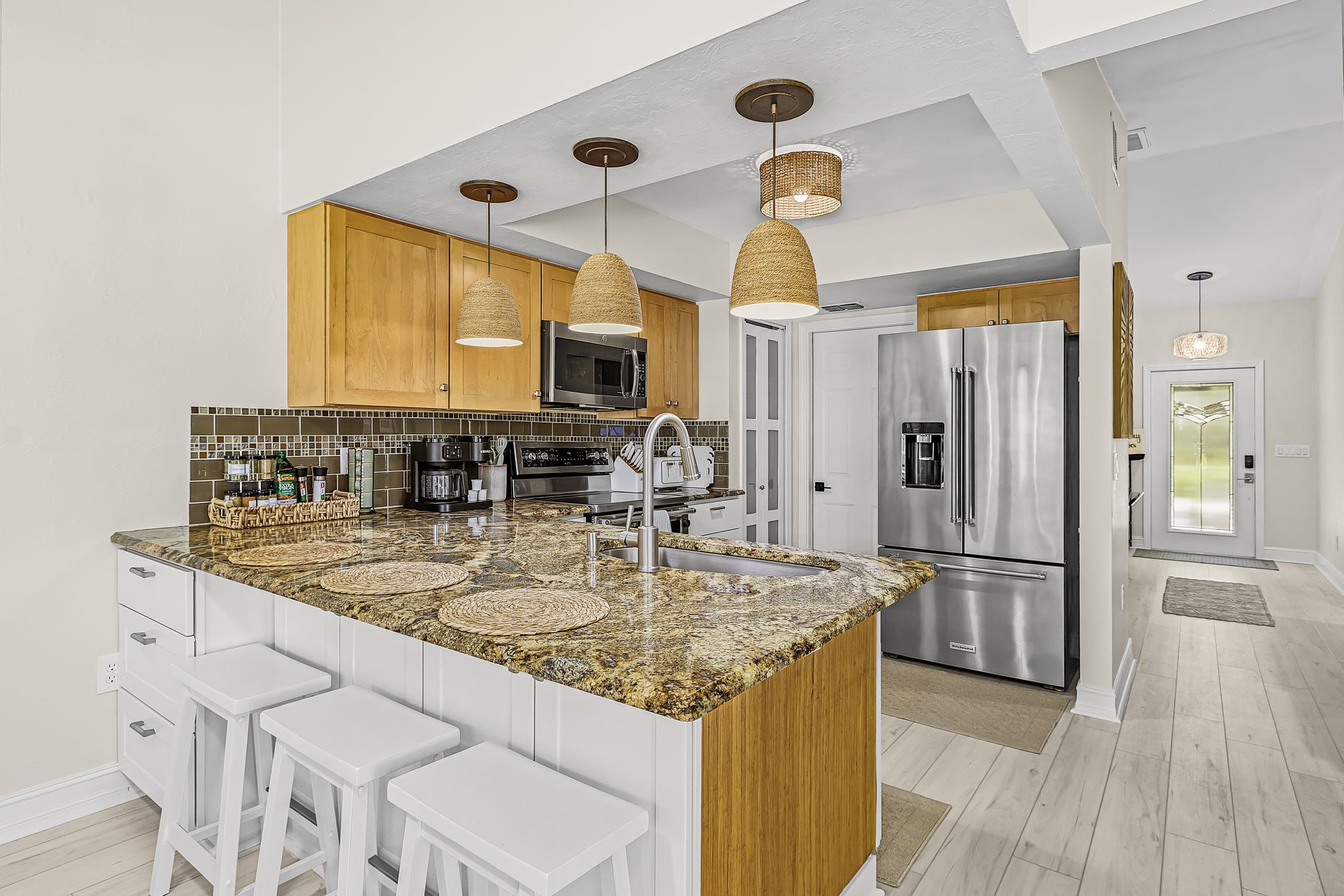 A modern kitchen with granite countertops, stainless steel appliances, and wooden cabinetry.
