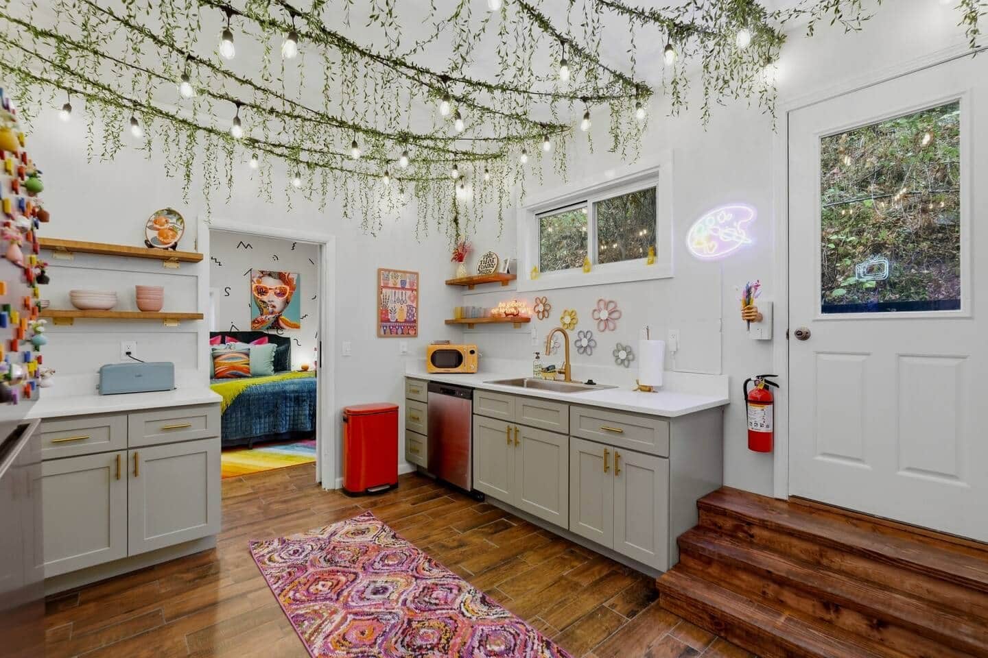 Een moderne keuken met een magnetron, spoelbak en houten kastjes.