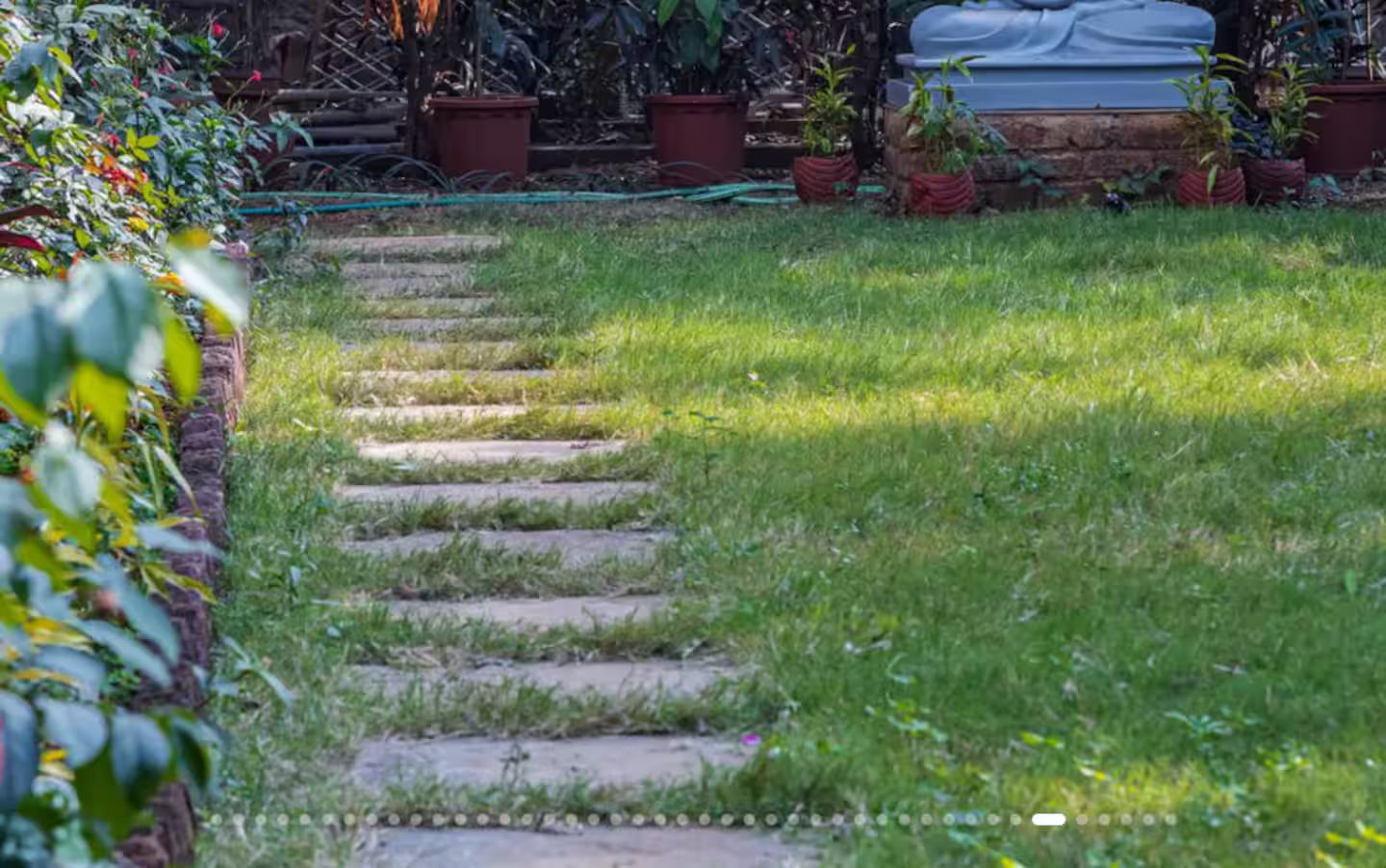 A garden pathway with steps leading to a seating area.