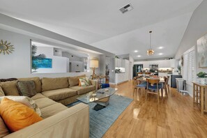 A modern living room with a sofa, coffee table, and dining area. - Private Pool, Spa & Game Room 4BR La Quinta (La Quinta)