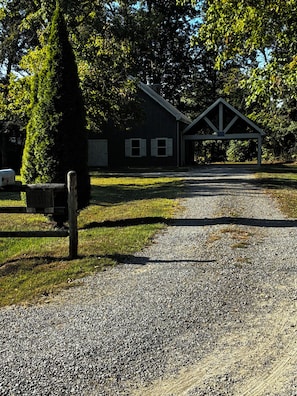 A gravel driveway leading to a building with a covered porch.