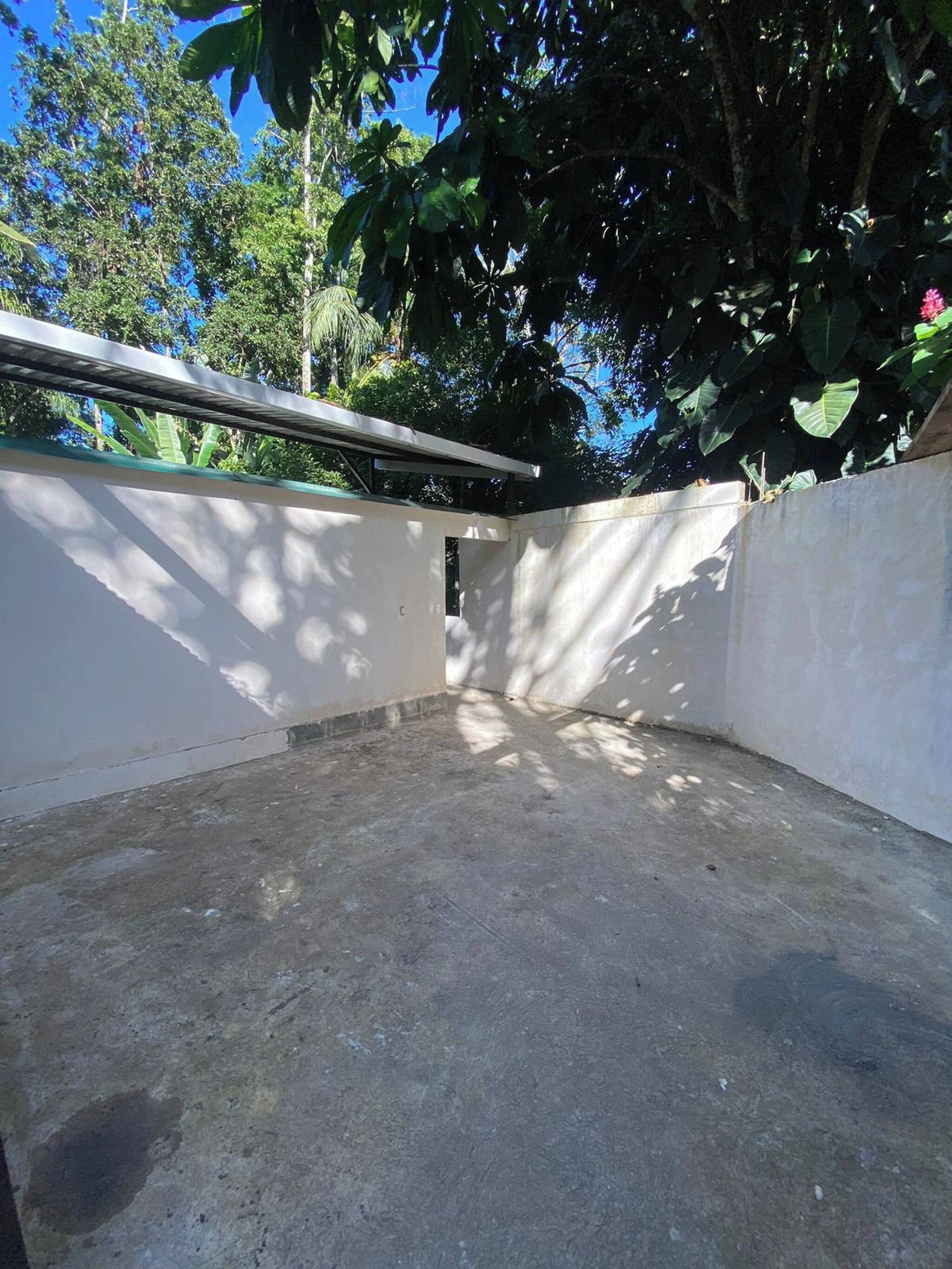 Piso de concreto com parede branca e viga de metal.