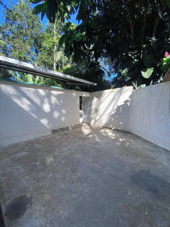 Piso de concreto com parede branca e viga de metal.