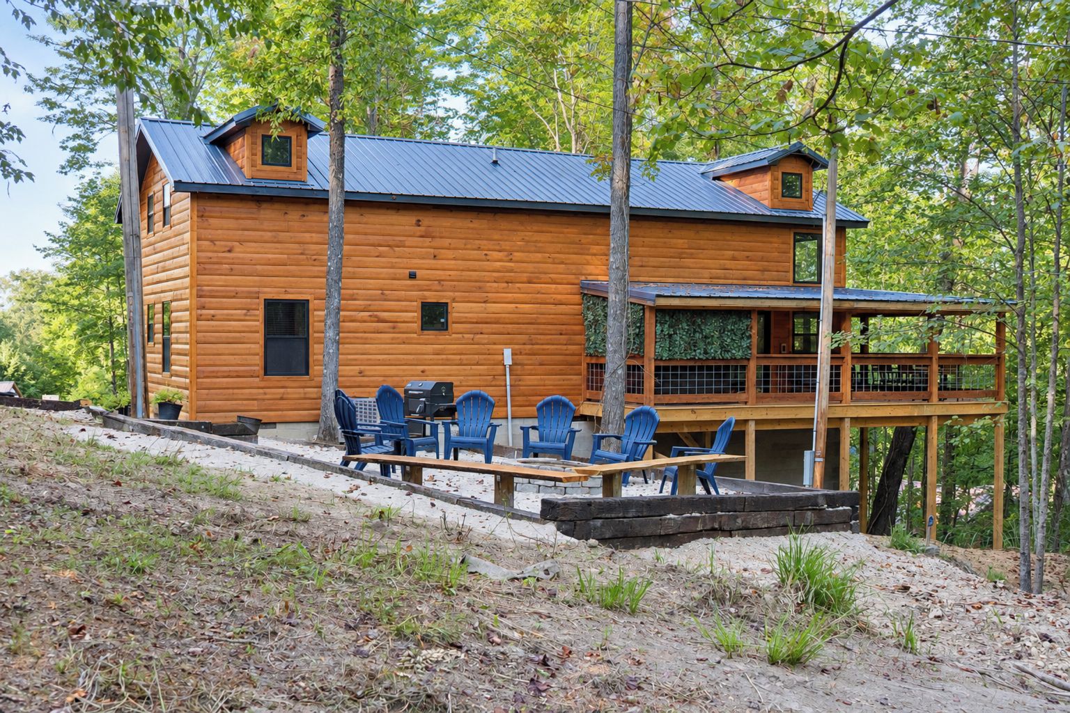 A log cabin with a deck and outdoor seating area.