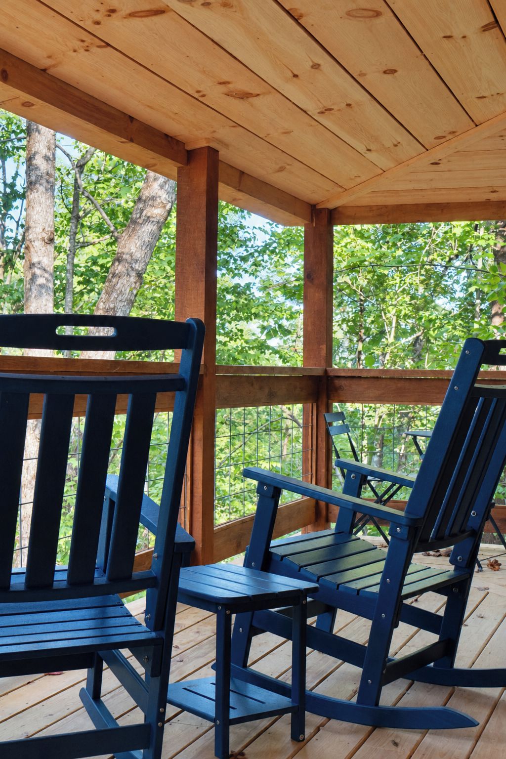 Un espace extérieur abrité, doté de bancs en bois et d’un plafond en bois.