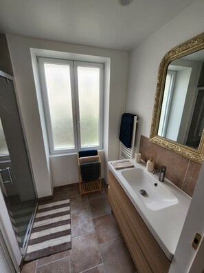 Un baño con bañera, lavamanos, espejo y ventana.