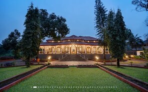 A building with a symmetrical facade, a central entrance with steps, and a well-maintained lawn. - Vintage Heritage Villa with Lawns & Garden Retreat (Lonavala)