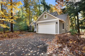 Ein Bungalow mit Garage, umgeben von Bäumen mit Herbstlaub.