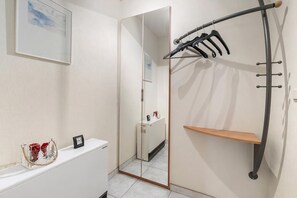 A bathroom with a white toilet, a mirror, a towel rack, and a small shelf. - Delvaux B 001 met garage (NIEUWPOORT)