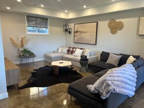 A modern living room with a sofa, a coffee table, and a rug.