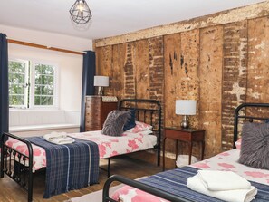 A room with two beds, a wooden wall, a window, and a lamp. - The Abbey Grange (Bridport)