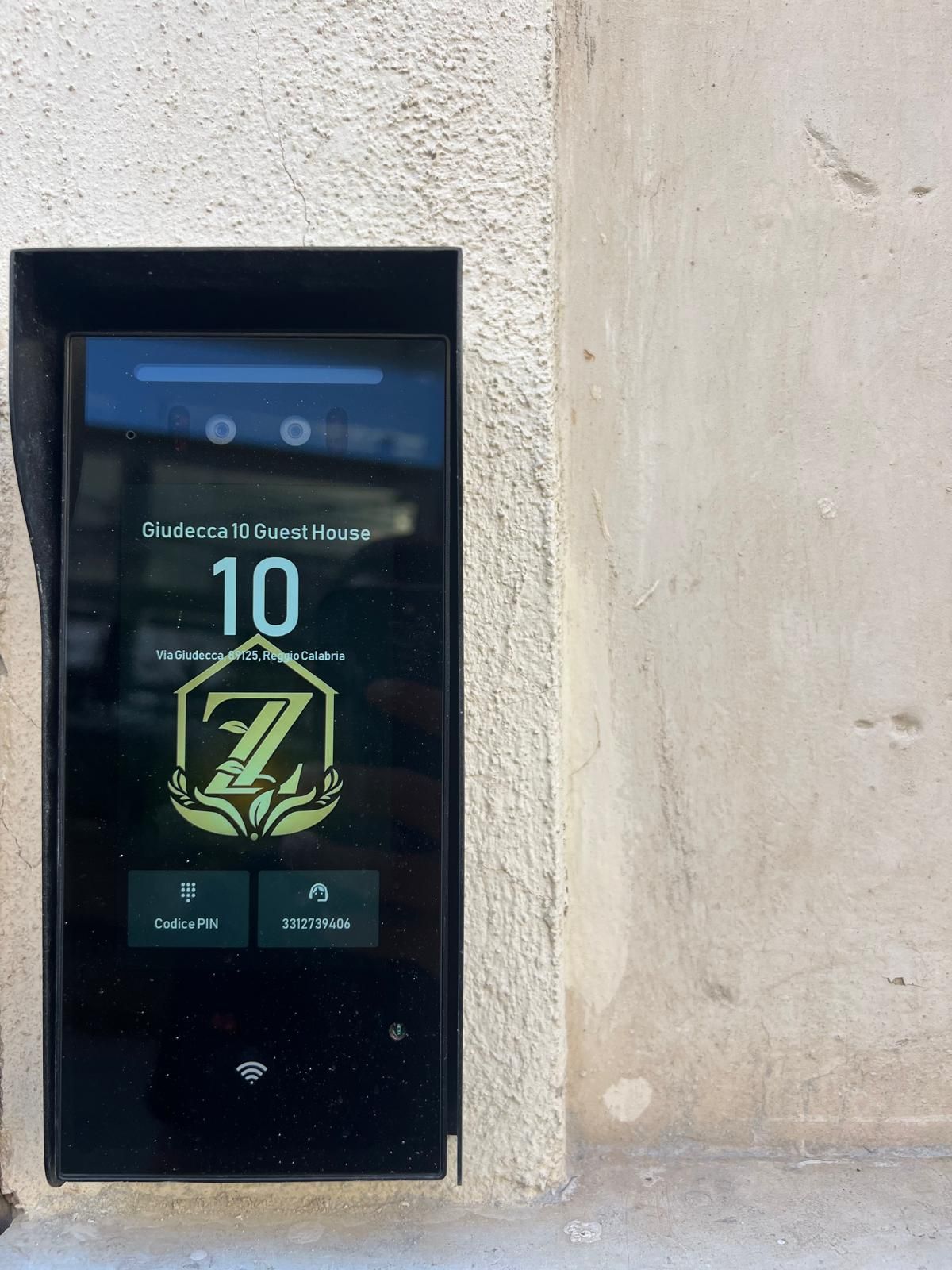 Giudecca 10 -vierastalon digitaalinen näyttö, jossa näkyy huoneen numero 10 sekä PIN-koodi ja Wi-Fi-symboli.
