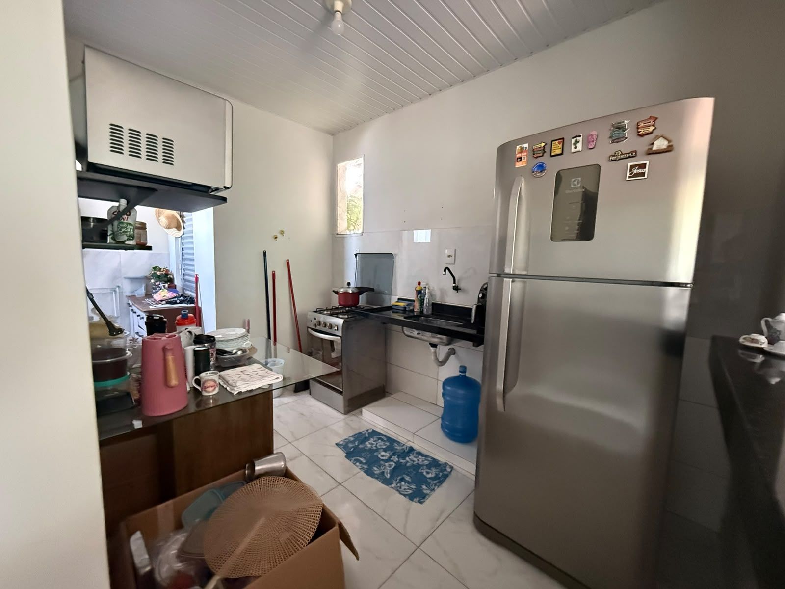 Una cocina compacta con refrigerador, estufa y lavaplatos.