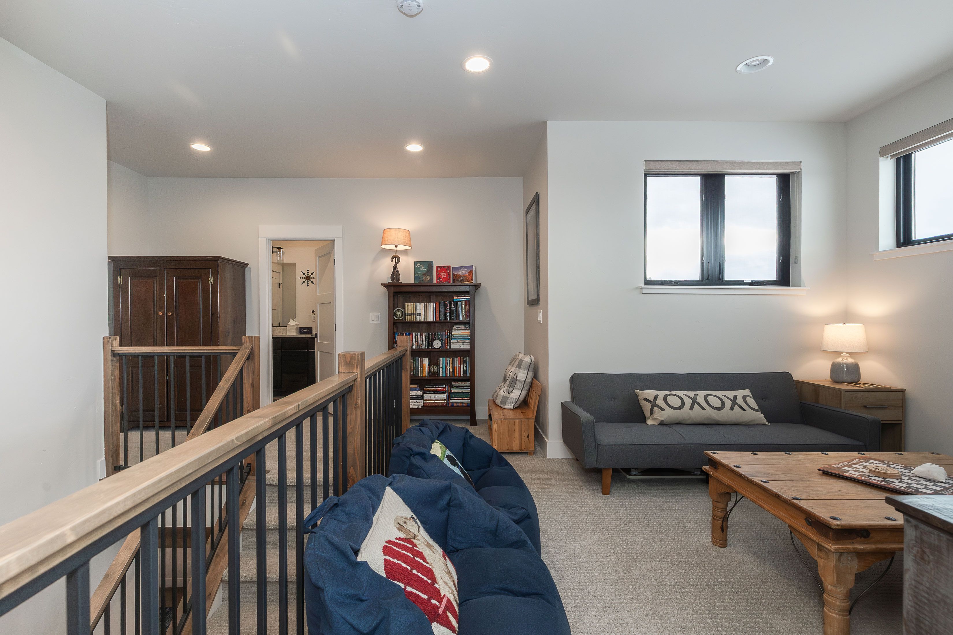 A spacious living room with a sofa, a coffee table, and a bookshelf.