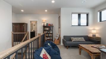 A spacious living room with a sofa, a coffee table, and a bookshelf.