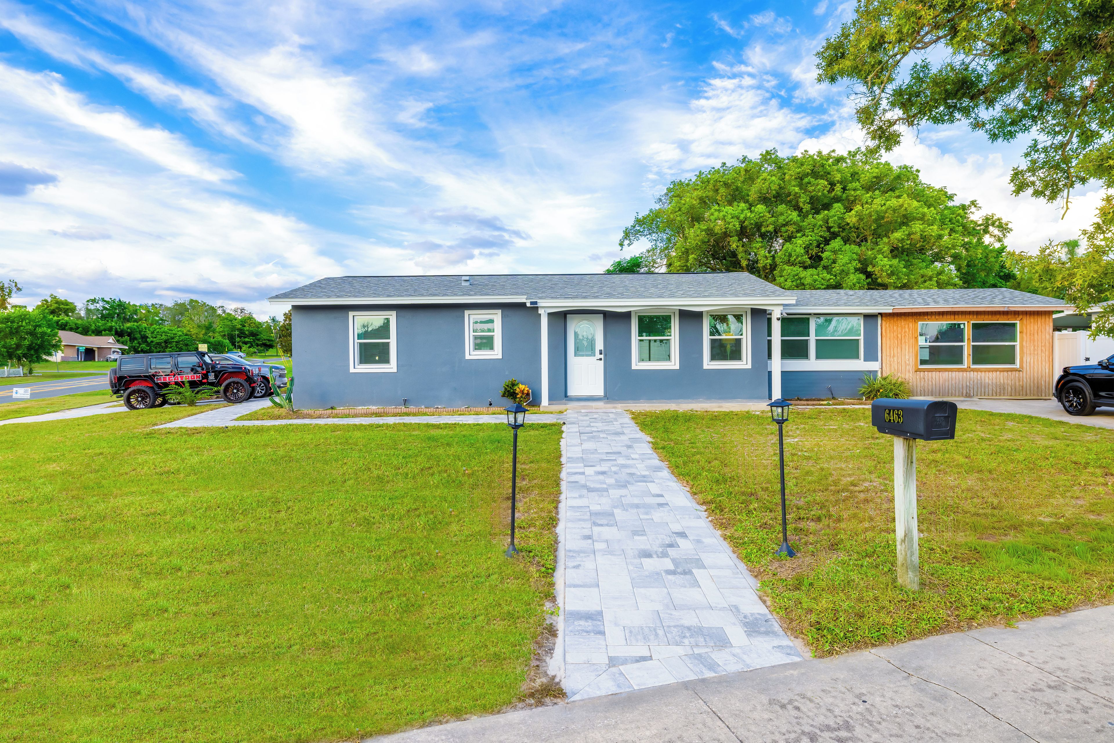 A residential house with a paved driveway, a mailbox, and a garage.