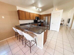 Fully stocked kitchen with spacious island seating, stainless steel appliances, and open flow to dining and living areas. - Family-Friendly Home Near Fort Huachuca with Fire Pit + Playroom (Sierra Vista)