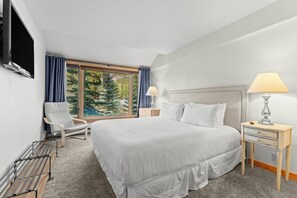 A hotel room with a large bed, a chair, a desk, a lamp, and a TV. - Skiers' Paradise in Keystone | 4BR Luxury Retreat | Shuttle Steps Away (Keystone)