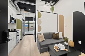 Een modern interieur met een kitchenette, een bank en een eethoek.