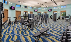 Ein Fitnessstudio mit verschiedenen Trainingsgeräten, Laufbändern und Kurzhanteln.