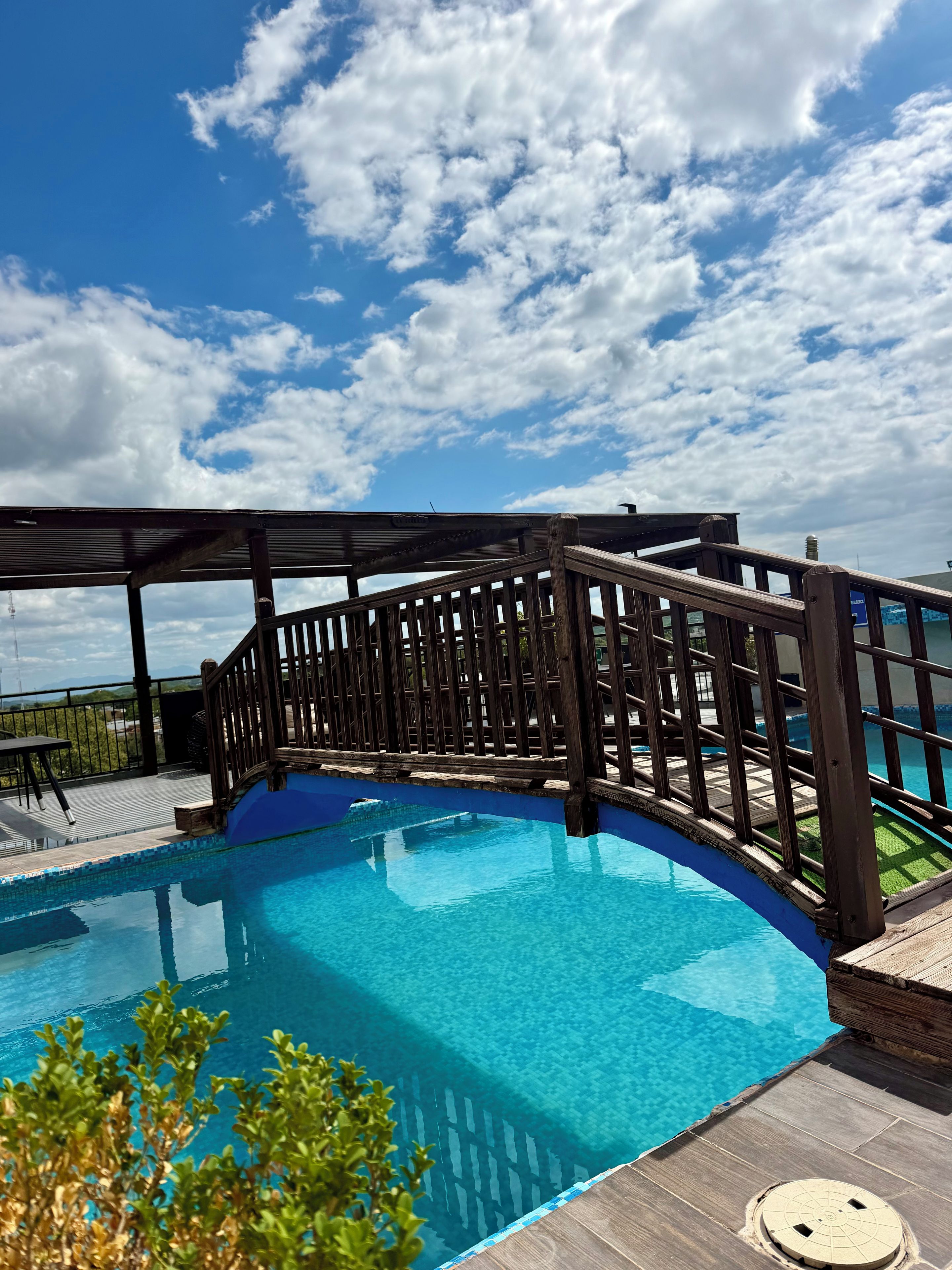 Una piscina con cubierta de madera y vista al cielo.